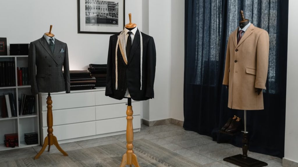 Stylish men's suits on mannequins in an atelier, showcasing luxury tailoring.